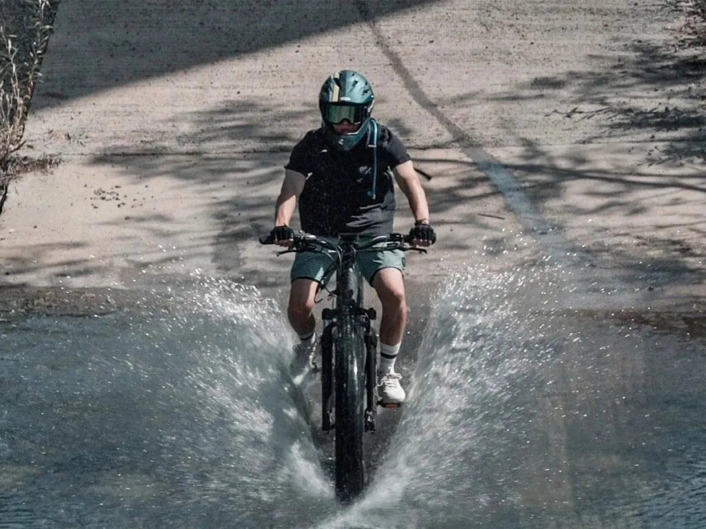 Rider splashing through water on a Himiway D7 Pro Cobra e-bike