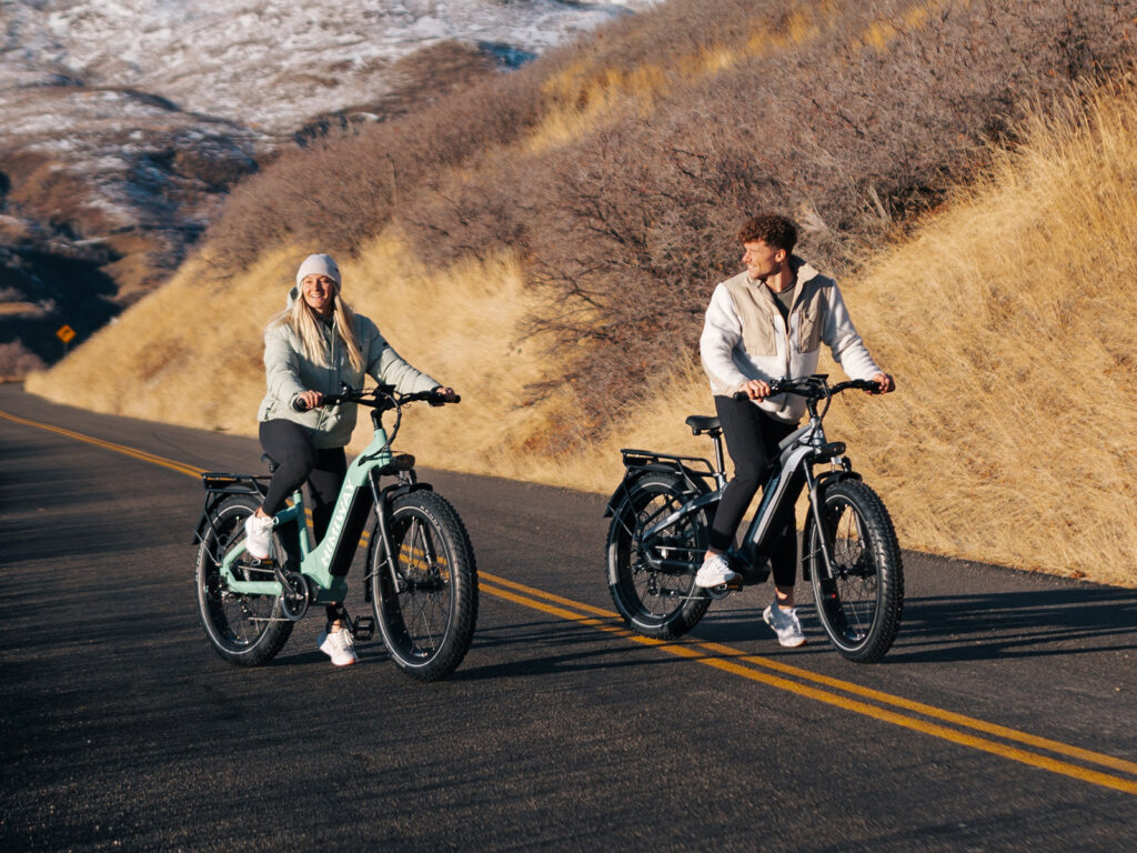 Two riders on Himiway fat tire e-bikes climbing a mountain road